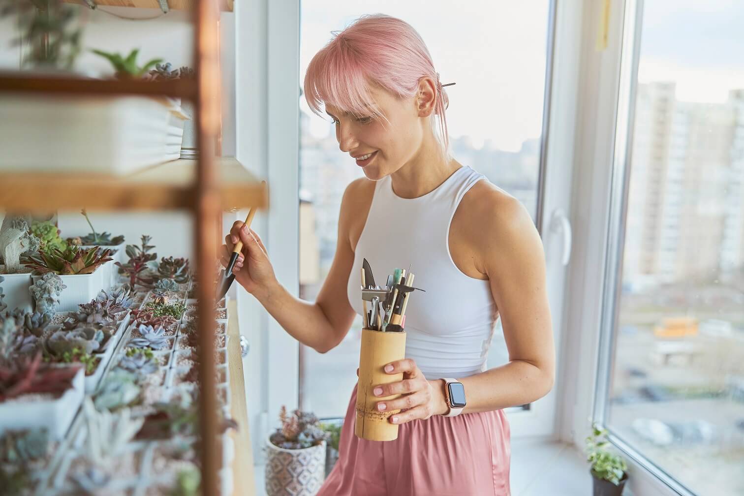 woman taking care of plants in balcony in Dubai